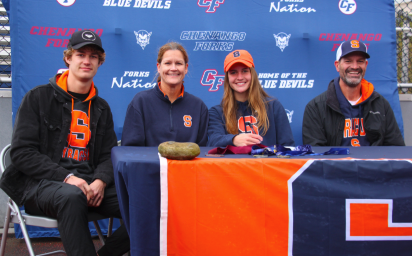 Pipher Reid with family at signing event table to sign for cross country
