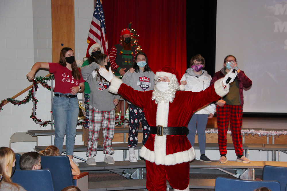 A group of high school students dancing on a stage with Santa for the elementary students