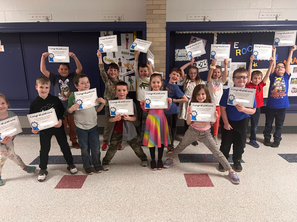 Top performers in the second grade poetry recitation  hold up certificates 