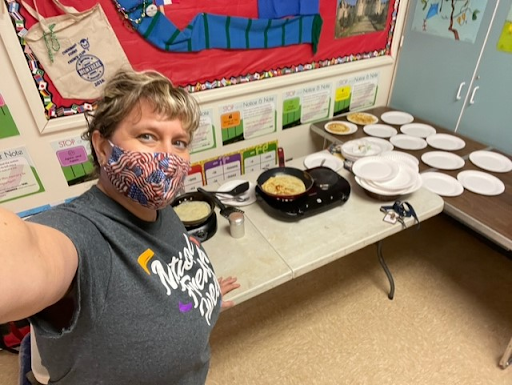 french 2 teacher "madame Ramsden" taking a selfie with tools to make crepes in her classroom